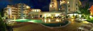 un hotel con piscina frente a un edificio en PMG Laguna Apartments, en Sunny Beach