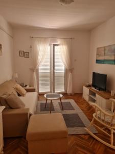 a living room with a couch and a tv at Apartman Martić in Klek