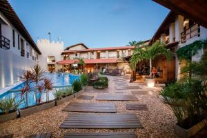 a courtyard of a building with a swimming pool at La Torre Resort All Inclusive in Porto Seguro