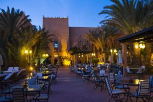a courtyard with tables and chairs in front of a building at Berbère Palace in Ouarzazate