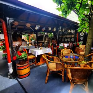 クルジュ・ナポカにあるクラマ ハイドゥチロールのテーブル、椅子、テーブル、椅子が備わるレストラン