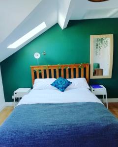 a bedroom with a large bed with a green wall at Big Yellow Door in Queens Quarter in Belfast