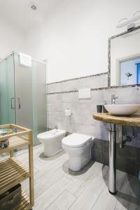 bagno con lavandino, servizi igienici e specchio di Rossetti Rooms a Trieste