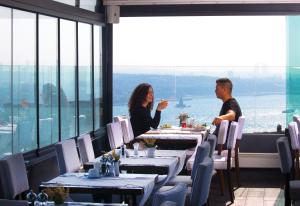 伊斯坦布尔City Center Hotel Taksim İstanbul的坐在餐厅桌边的一对男女