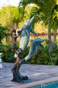une statue de dauphins perchée sur une branche d'arbres dans l'établissement Dolphin Cove, à Freeport