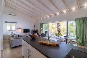 uma cozinha e sala de estar com um sofá e uma mesa em Zoela Corfu - 2 Seperate Houses With Full Privacy em Gastouri