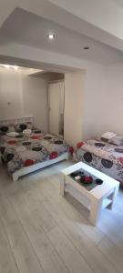 een kamer met twee bedden en een tafel erin bij Studio Apartman KOCKA in Belgrado