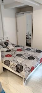 een slaapkamer met een bed met een zwart-rode quilt bij Studio Apartman KOCKA in Belgrado