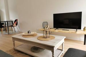 a living room with a coffee table and a tv at Le LORENZO - hypercentre, cosy et vue Loire in Blois