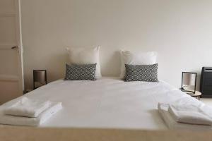 a large white bed with two towels on it at Le LORENZO - hypercentre, cosy et vue Loire in Blois