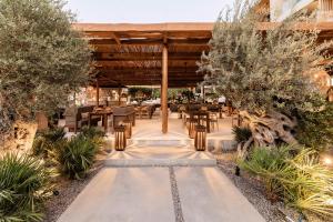 um restaurante ao ar livre com mesas, cadeiras e árvores em Lindos Aqua Terra em Lindos