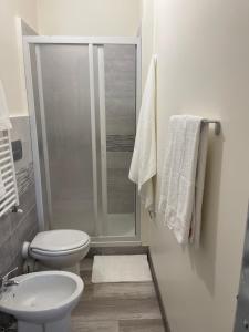La salle de bains blanche est pourvue d'une douche et de toilettes. dans l'établissement casa vacanza Antico Baglio, à Castelbuono
