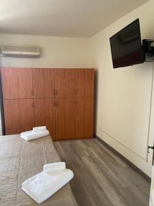 a room with two beds and a flat screen tv at casa vacanza Antico Baglio in Castelbuono