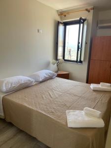 - une chambre avec un grand lit et une fenêtre dans l'établissement casa vacanza Antico Baglio, à Castelbuono