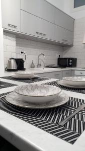 una cucina con 3 piatti bianchi su un bancone di Alexandra's Boutique House a Triovasálos