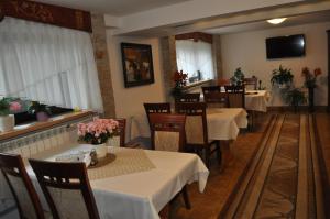 a restaurant with tables and chairs with flowers on them at Pokoje u Marysi in Leśnica