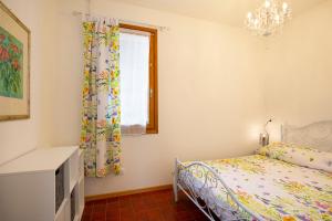 sypialnia z łóżkiem i oknem w obiekcie Appartamento Albert - Stresa w mieście Stresa