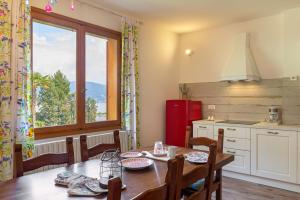 een keuken met een houten tafel, een tafel en een raam bij Appartamento Albert - Stresa in Stresa