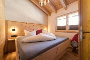 a bed in a small room with a window at Quality Hosts Arlberg - ALPtyrol Appartements in Sankt Anton am Arlberg