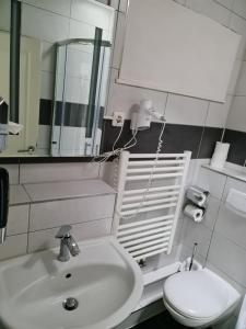 La salle de bains est pourvue d'un lavabo, de toilettes et d'un miroir. dans l'établissement Shop 23, à Hambourg
