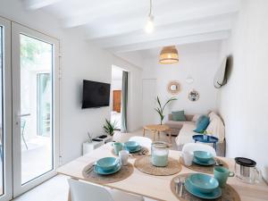 ein weißes Wohnzimmer mit einem Tisch und Stühlen in der Unterkunft La Cala Malmousque - Magnifique petite maison au bord de l'eau in Marseille