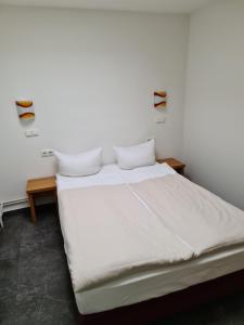 un letto con lenzuola e cuscini bianchi in una stanza di Shop 23 ad Amburgo