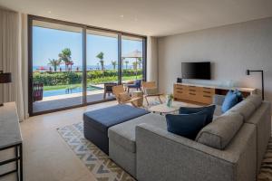 a living room with a couch and a television at Amara - Sea Your Only View™ in Limassol