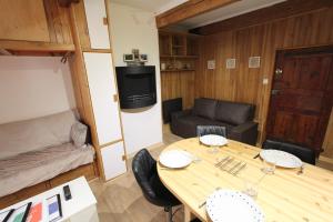 a small room with a wooden table and a couch at Charmant Studio Cité Vauban in Briançon