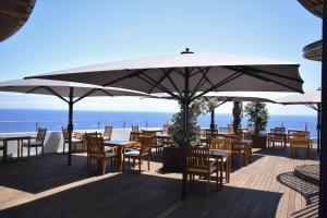 un restaurant avec des tables, des chaises et des parasols dans l'établissement Madeira Regency Cliff - Adults Only, à Funchal