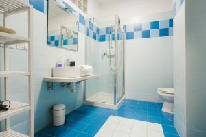 uma casa de banho azul e branca com um chuveiro e um WC em Grab a Flat in Coroneo em Trieste