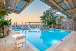 a swimming pool with a table and chairs next to it at Aphea Village by GHH in Kolymvari +43 photos