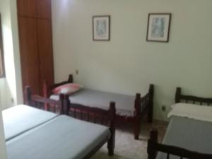 - une chambre avec deux lits et deux chaises dans l'établissement Casa a 50 metros da Praia da Riviera no Jardim São Lourenço - Casa com Wi-Fi, à Bertioga