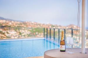 een fles champagne op een tafel naast een zwembad bij Villa Amplitude in Câmara de Lobos