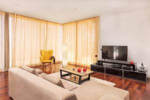 een woonkamer met een bank en een televisie bij Villa Amplitude in Câmara de Lobos