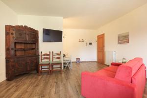 een woonkamer met een rode bank en een tafel bij Appartamento Albert - Stresa in Stresa