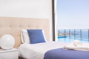 een slaapkamer met een bed en een groot raam bij Villa Amplitude in Câmara de Lobos +37 foto's