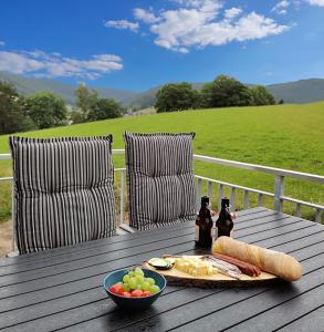 a table with a plate of food and a bowl of fruit at Adlerhorst in Baiersbronn