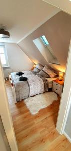 Schlafzimmer im Dachgeschoss mit 2 Betten und einem Teppich in der Unterkunft Ferienhaus Darlingerode in Darlingerode