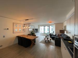 sala de estar con mesa y sofá en Cosy Appartement- 2 slaapkamers schuin zeezicht met Garage, en Knokke-Heist