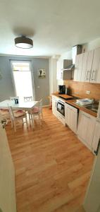 a kitchen with a wooden floor and a table and a dining room at Ferienhaus Darlingerode in Darlingerode