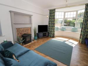 a living room with a blue couch and a fireplace at Monarfon in Amlwch