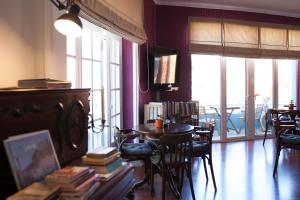 a living room with a table and chairs and windows at Hotel Leiria Classic in Leiria