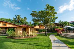 a house with a lawn and a sidewalk at Hotel Pousada Imbassai in Imbassai