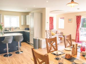 a kitchen and living room with a table and chairs at Swallows Dip in Honiton