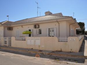 a house with a fence and an umbrella at Sagittarius Mare in Marina di Ragusa