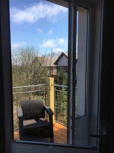 a window with a chair sitting on a balcony at Koralia Domki i Apartamenty Basen z podgrzewaną wodą in Sarbinowo