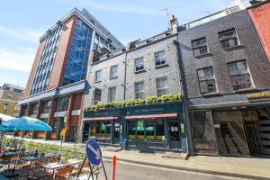 a street with tables and chairs in front of buildings at Berwick Street by Q Apartments in London