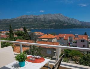 een balkon met een tafel en uitzicht op de stad bij Apartments Filippi in Korčula