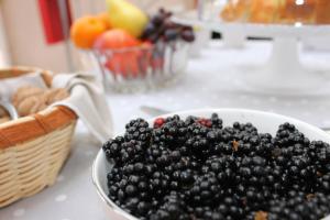 eine Schüssel Brombeeren auf einem Tisch mit einem Obstkorb in der Unterkunft Il giardino degli aranci in Modolo