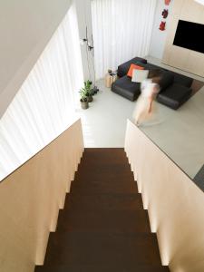 eine Treppe in einem Wohnzimmer mit einer Person, die sie hinuntergeht in der Unterkunft Criu Boutique Hotel in Nicolosi